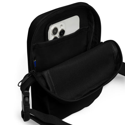 Black crossbody bag with a phone inside on a white background