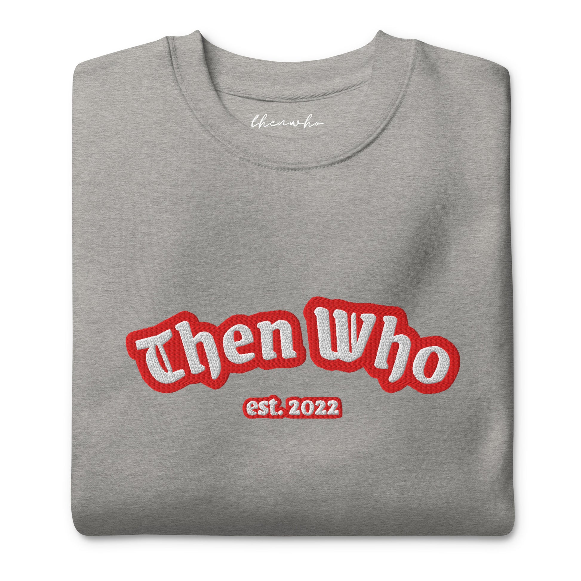 Folded gray sweatshirt with 'Then Who est. 2022' text in red and white on a white background